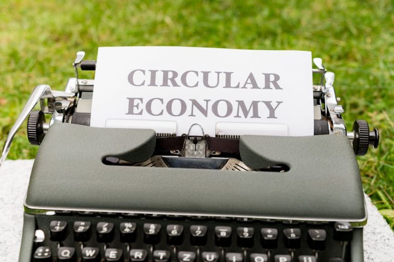 Classic typewriter displaying 'Circular Economy' in outdoor setting, conveying sustainability.