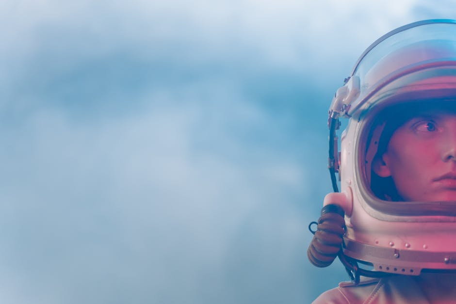 Portrait of an astronaut in a spacesuit helmet against a soft sky, evoking the mystery of space.