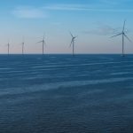 Scenic view of offshore wind turbines against a calm sea in Flevoland, promoting renewable energy.