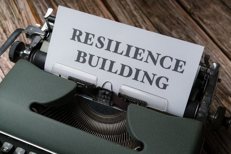 A vintage typewriter with the words 'RESILIENCE BUILDING' on a paper sheet.