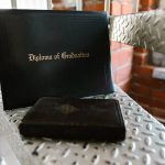 Beyond the Degree: Why Proprietary Learning Loops are the New Competitive Moat Close-up of a diploma and book on a metal staircase indoors, symbolizing academic achievement.