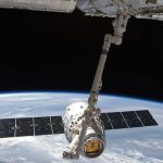 Beyond the Frontier: Why Space Commercialization Needs a New Governance Model View of a spacecraft docked at the ISS above Earth with visible solar panels.
