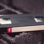 Close-up of a vintage VHS tape resting on a textured surface, offering nostalgic appeal.