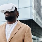 Bio-Digital Convergence: The New Frontier of Business Strategy A man wearing VR glasses and a coat, engaging with virtual reality technology outdoors.