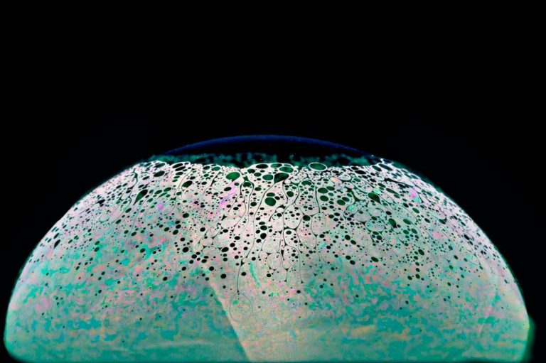 A captivating abstract image of a soap bubble resembling a surreal planet with cellular patterns.