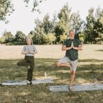Biological Longevity Strategy: Elite Performance for Leaders An elderly couple doing yoga in a serene park setting, promoting a healthy lifestyle.