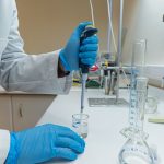 Biological R&D Compression: Scaling Biotech Decision Velocity Lab scientist using pipette in chemical experiment with precision.