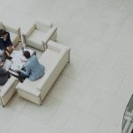 Biopolitics in Business: Managing Human Systems and Performance Aerial view of a business team discussing documents in a modern office setting.