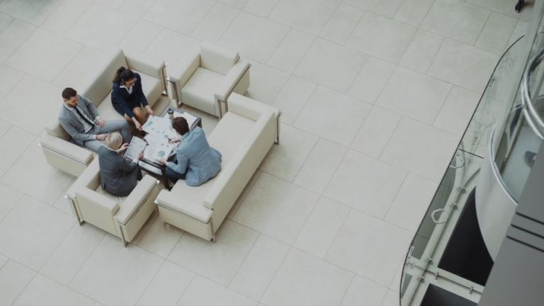 Aerial view of a business team discussing documents in a modern office setting.