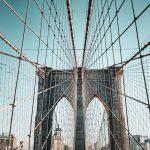 Stunning architectural detail of the Brooklyn Bridge against a clear sky, showcasing its iconic cables.