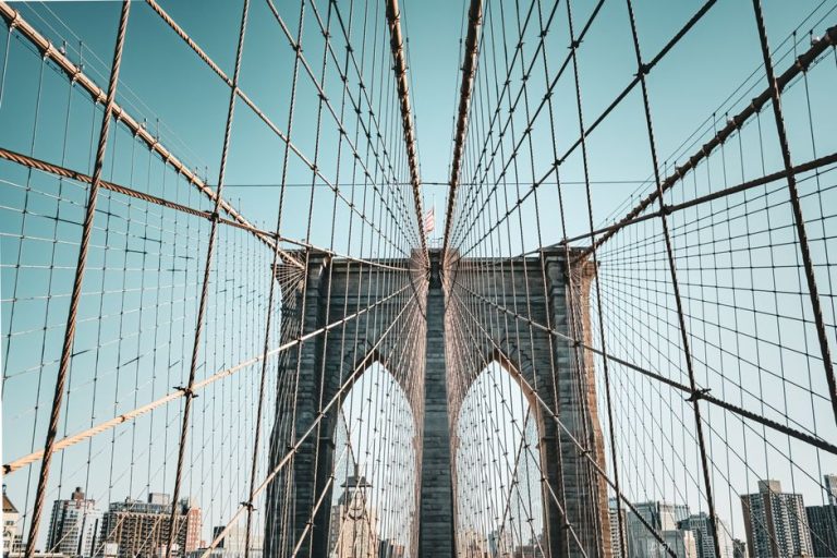 Stunning architectural detail of the Brooklyn Bridge against a clear sky, showcasing its iconic cables.