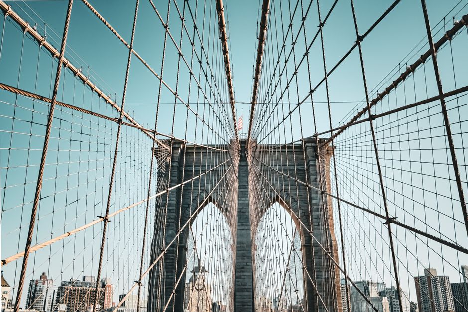 Stunning architectural detail of the Brooklyn Bridge against a clear sky, showcasing its iconic cables.