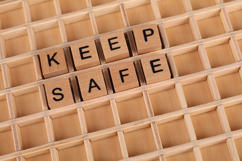 Wooden blocks spelling "Keep Safe" on a grid background. Ideal for messages of security and care.