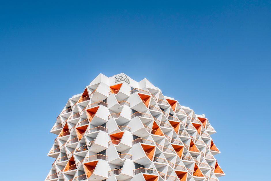A stunning geometric architectural design against a vibrant blue sky in Dubai.