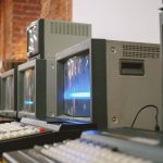 Row of vintage CRT computer monitors showcasing classic technology indoors.
