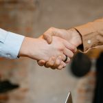 Consensus Mechanisms in Business: Scaling Decision Protocols Close-up of a firm handshake symbolizing a business deal agreement.