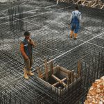 Constitutional Frameworks: The Foundation of High Performance Workers preparing steel reinforcement at a construction site for concrete foundation.