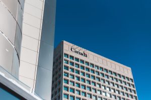 Low angle view of a modern skyscraper in Canada against a clear blue sky.
