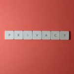 Data Privacy as Strategy: Reducing Liability and Maximizing ROI Close-up of letter tiles spelling PRIVACY on a red background, symbolizing data protection.