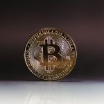 Decentralized Cloud Strategy: Building Resilient Infrastructure A close-up of a shiny Bitcoin coin on a reflective surface, highlighting cryptocurrency finance.