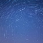 Long exposure image capturing mesmerizing star trails swirling in a clear night sky.