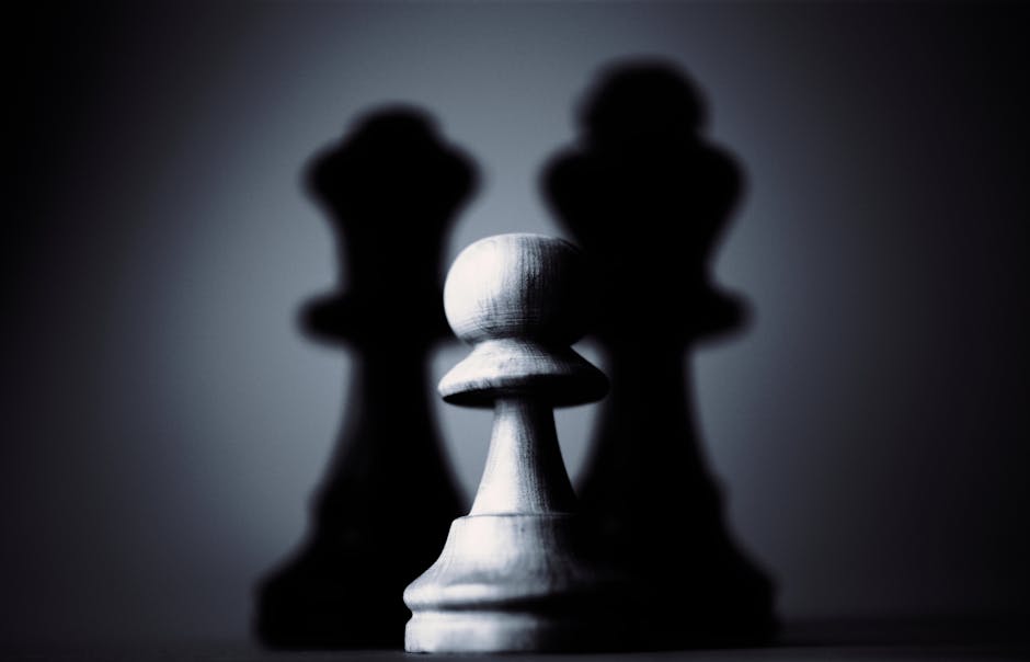 Moody black and white photograph of a chess pawn highlighting strategy and shadow play.