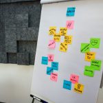 Democratization of Knowledge: Strategy for Modern Leadership An office whiteboard filled with colorful sticky notes showcasing teamwork and creativity concepts.