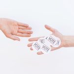 Digital Civic Engagement: Strategy for 21st Century Governance Close-up of hands exchanging vote stickers, symbolizing engagement in democratic election.