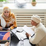 Digital Transformation: Why Empowerment Needs Autonomy, Not Tools Three women in hijabs collaborating on digital advertising strategies around a table with laptops.