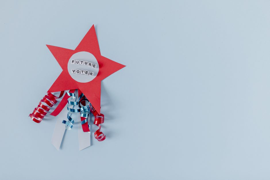 Red star with 'Future Voter' text and ribbons on a pastel blue background.