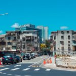 Dynamic Urban Infrastructure: Strategy for Resilient Systems A vibrant urban street with cars, construction, and classic city buildings under a clear blue sky.