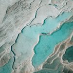 Earth's Thermal Governor: Understanding AMOC and Climate Risk A stunning aerial shot of turquoise thermal pools surrounded by white limestone formations, creating a natural abstract pattern.