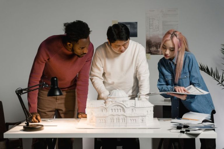 A diverse group of professionals discussing an architectural model in an office setting, emphasizing teamwork.