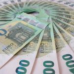 Close-up of fan spread 100 Euro banknotes, showcasing wealth and finance theme.