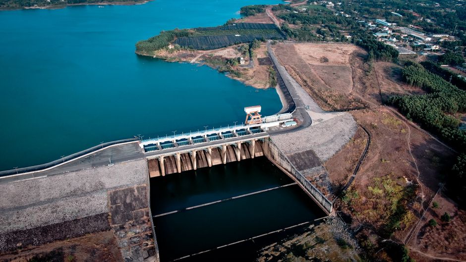 Drone shot capturing an impressive dam with vast reservoir and scenic surroundings.
