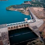 Energy Sovereignty: Strategic Micro-Grid Resilience for Business Drone shot capturing an impressive dam with vast reservoir and scenic surroundings.