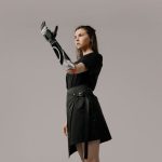 Enhancing Human Perception for High-Stakes Decision-Making Empowering portrait of a young woman showcasing a futuristic prosthetic arm in a studio setting.