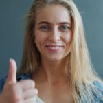 Epigenetic Optimization: Master Your Biology for Performance Confident woman with a thumbs up gesture, showing positivity and agreement.