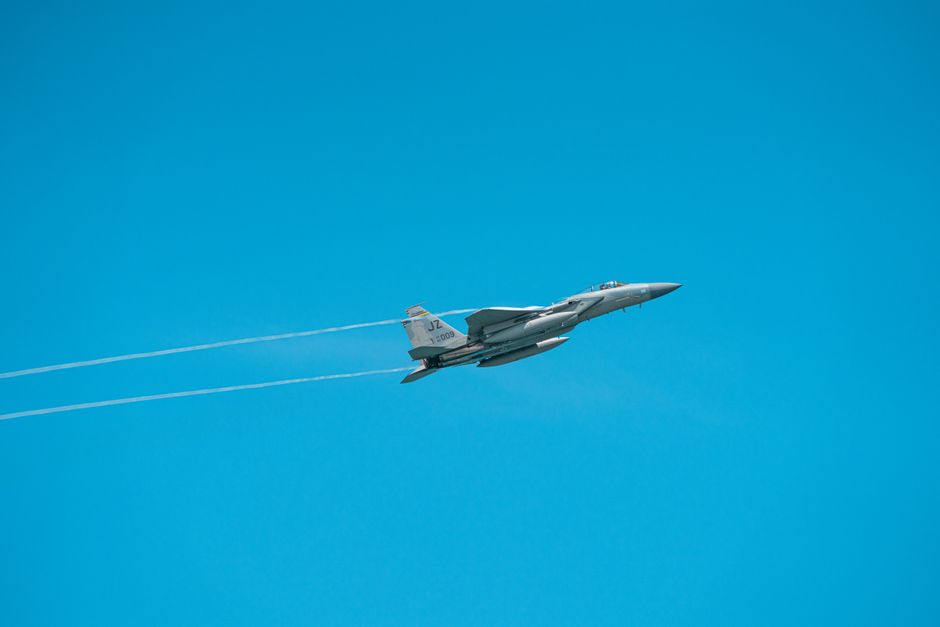 A military jet flies through a clear sky, showcasing agile aerial maneuverability.