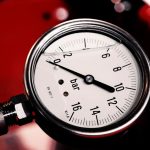 Detailed view of a bar pressure gauge used in industrial settings, emphasizing precision and measurement.