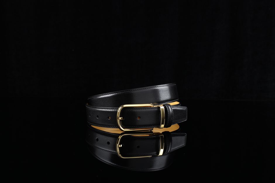Sophisticated black leather belt featuring a sleek gold buckle, perfect for fashion-forward styling.