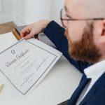A man holding a divorce certificate in a formal office environment.