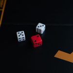 Game Theory in Business: Mastering Strategic Leadership A close-up of red and white dice on a board game, evoking a sense of fun and strategy.