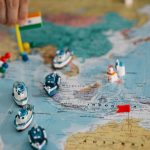 Global Connectivity Strategy: Unlocking Market Expansion in 2026 A detailed view of a world map with tiny model ships and flags indicating locations, highlighting global trade routes.