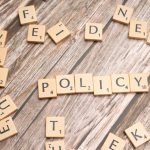 Governance as Strategy: How Policy Enables High Performance Scrabble letter tiles on a wooden background forming the word "Policy".