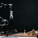 A robotic arm engages in a chess match, showcasing AI and robotics in a studio setup.