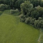 Drone view of lush green fields and forest in Muttersholtz, Grand Est, France.
