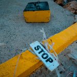 How to Stop Operational Decay with Protocol 230 | Business Tips Close-up of a weathered stop sign on a yellow-painted curb, conveying caution.