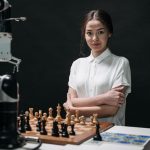 Human-Robot Collaboration: A Strategic Guide to Integration A young woman in a white blouse playing chess against a robot arm.
