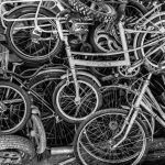 Infinite-Cycle Recycling: A Strategic Moat for Modern Business Chaotic pile of old bicycles in black and white, showcasing urban decay and recycling themes.